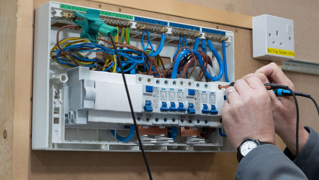 An electrician carrying out Inspection and Testing on a consumer unit