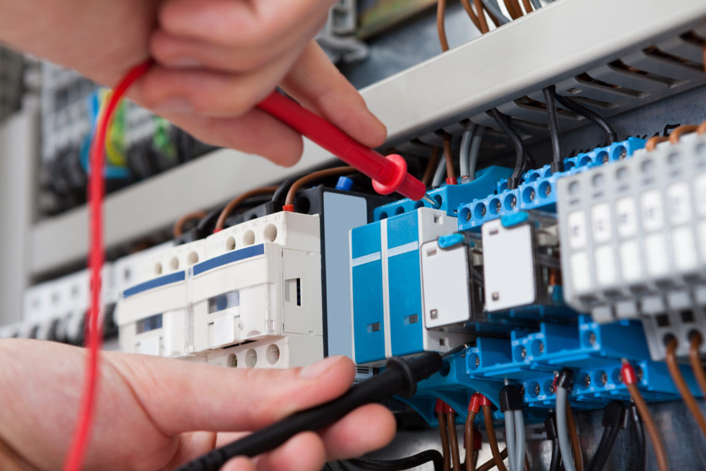 An electrician conducting Inspection and Testing on an electrical installation